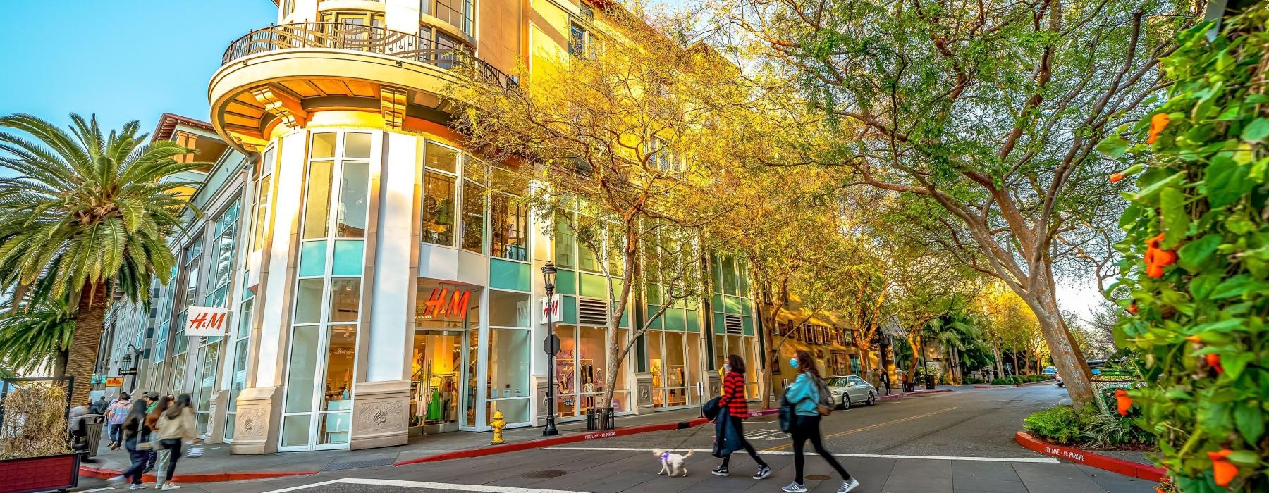 a building with trees and people walking around